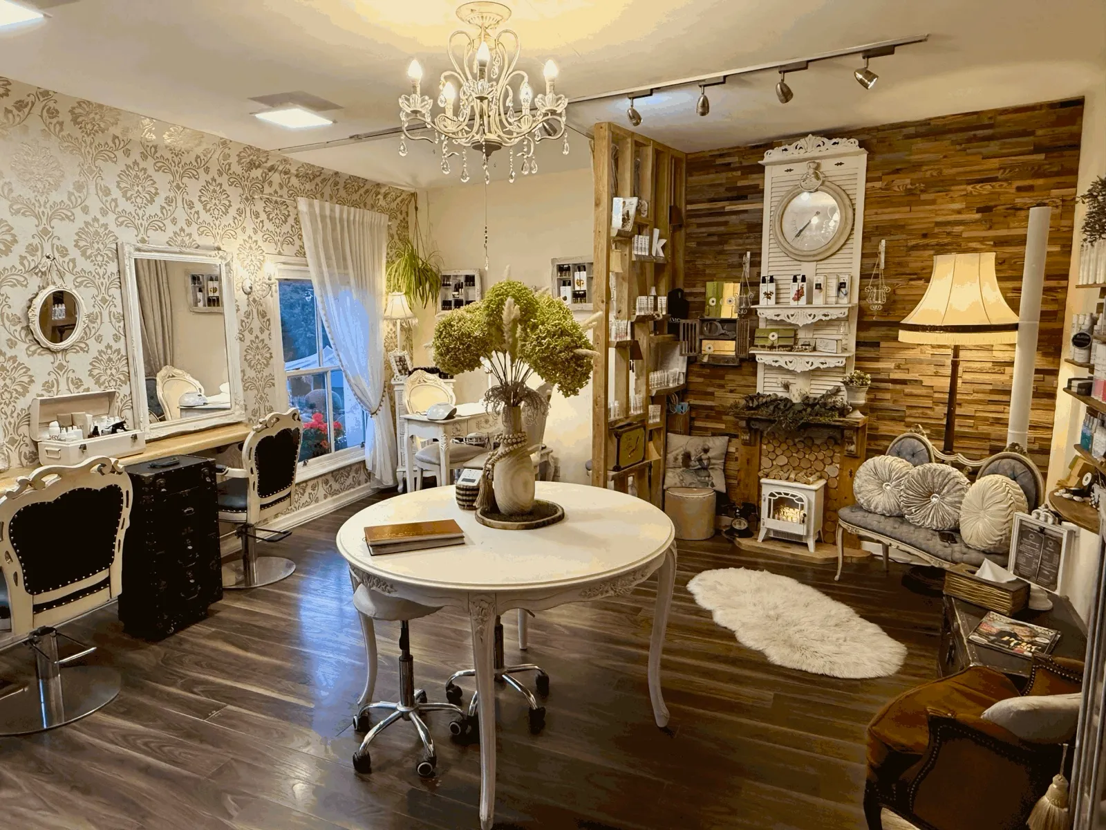 Inside the salon: styling chairs, chandelier, round table and the fireplace corner